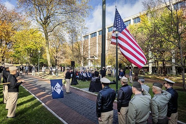 people gathered on campus green to observe rotc flag raising ceremony